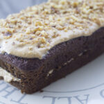 a vegan coffee and walnut loaf cake on a cake stand