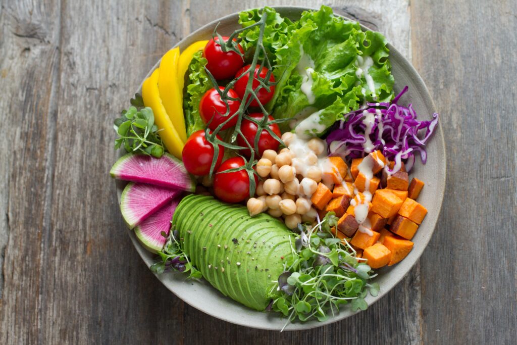 Vegan Family Meal Plan 18th January 2021 1 plate of plant based foods including avocado, cress, sweet potato, chickpeas, tomatoes, peppers, lettuce and cabbage, all chopped and drizzled with dressing