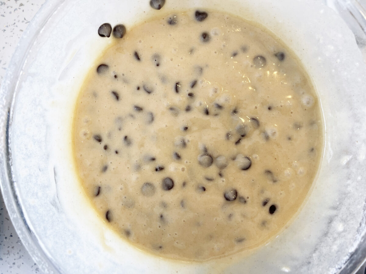 Easy Vegan Chocolate Chip Muffins (Bakery-Style) 194 Vegan chocolate chip muffin batter mixed together in a clear mixing bowl.