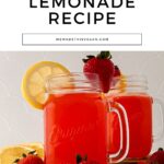 Two mason jar mugs filled with strawberry pink lemonade, garnished with lemon slices and strawberries, placed on a white surface with text above reading "Pink Strawberry Lemonade Recipe".