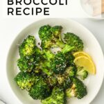 A plate of air-fried broccoli seasoned with spices, garnished with lemon slices. Text above reads "We Made This Vegan Air Fryer Broccoli Recipe: Learn How to Air Fry Broccoli Perfectly.
