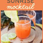 An orange mocktail labeled "Tequila Sunrise Mocktail" is garnished with lime slices and served in sugar-rimmed glasses on a wooden surface, perfectly capturing the essence of its spirited counterpart without the alcohol.