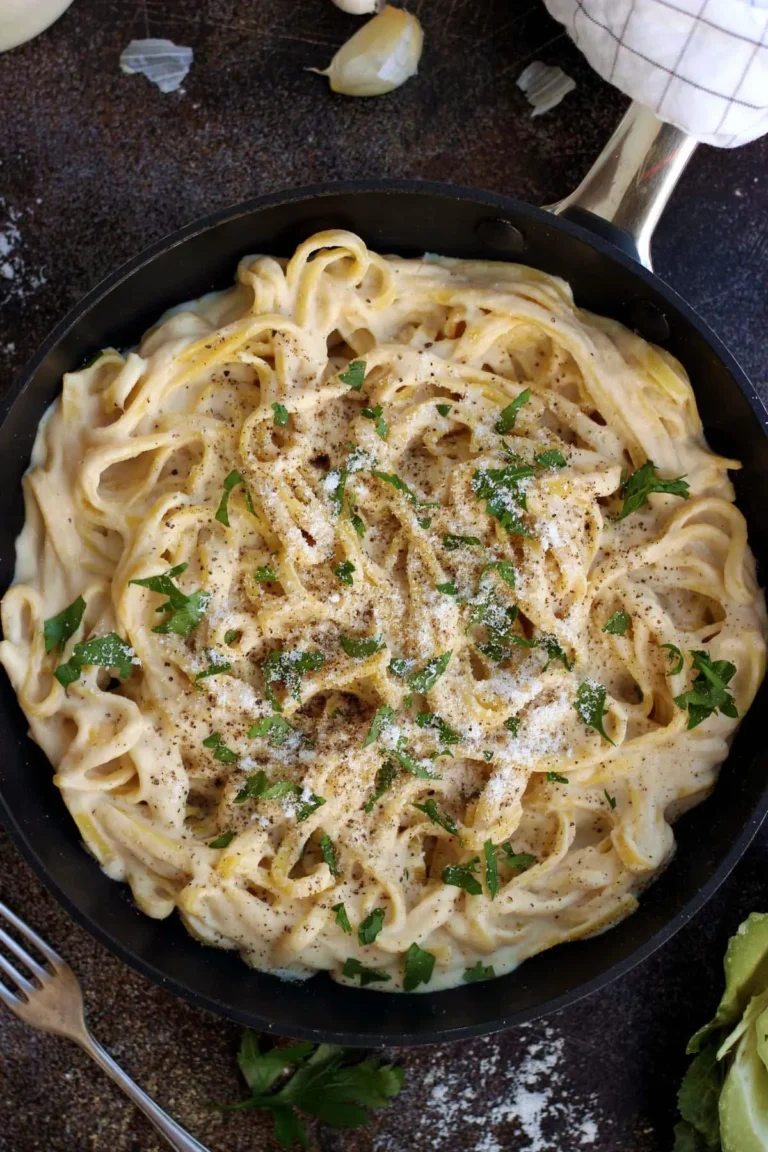 High Calorie Vegan Recipes - Meals For Weight Gain 17 A skillet filled with creamy, high-calorie fettuccine Alfredo, garnished with parsley and black pepper.