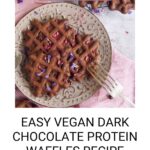 Plate of scrumptious vegan dark chocolate waffles adorned with delicate flowers, accompanied by a fork. Text reads: "Easy Vegan Dark Chocolate Protein Waffles Recipe" with a website link below.