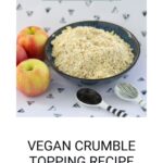 A bowl of vegan crumble topping sits beside two apples, accompanied by a black and white spoon and fork on a patterned surface. Text reads "DELICIOUS VEGAN CRUMBLE TOPPING RECIPE.