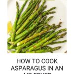 Plate of delicious asparagus cooked to perfection in an air fryer, garnished with red pepper flakes and a lemon slice on the side. Text: "How to Cook Asparagus in an Air Fryer" at the bottom.