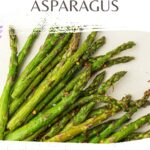 Deliciously cooked asparagus in an air fryer, seasoned to perfection, showcased on a crisp white background. Check out "Air Fryer ASPARAGUS" and visit wemadethisvegan.com for the full recipe.