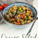 A bowl of high protein quinoa salad with black beans, corn, cherry tomatoes, and herbs sits on a table with a fork; text at the bottom reads "Quinoa Salad, Vegan & High Protein.