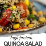 Close-up of a high protein quinoa salad with black beans, corn, chickpeas, red bell pepper, and herbs in a bowl, with text reading "high protein QUINOA SALAD RECIPE.