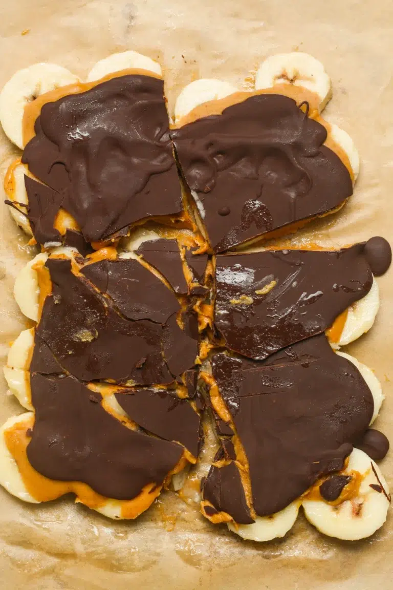 50 Delicious Vegan Desserts With Fruit That You Will Love 42 Banana slices topped with peanut butter and a layer of chocolate, broken into irregular pieces on parchment paper-an easy and delicious option for vegan desserts with fruit.