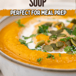 Close-up of a bowl of creamy vegan roasted pumpkin soup garnished with fresh herbs, pumpkin seeds, and a swirl of cream. Text overlay reads, "Creamy Pumpkin Soup, Perfect for Meal Prep.
