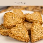 A plate of heart-shaped keto biscuits coated with sesame seeds, labelled as dairy-free and gluten-free Valentine’s biscuits.