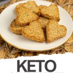 A plate of heart-shaped keto biscuits sits on a woven placemat, with text below reading “Keto Gluten Free Valentine’s Biscuits.” Perfect for those seeking delicious dairy free biscuits to celebrate love.